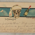 Lot 107 - Single Antique Postcard, "The Morning After" With Skull Smoking A Cigarette, Bottle Of Alcohol, Copyright 1905 By Blaesi & Bell, After A.M.C. Bell, 1904
