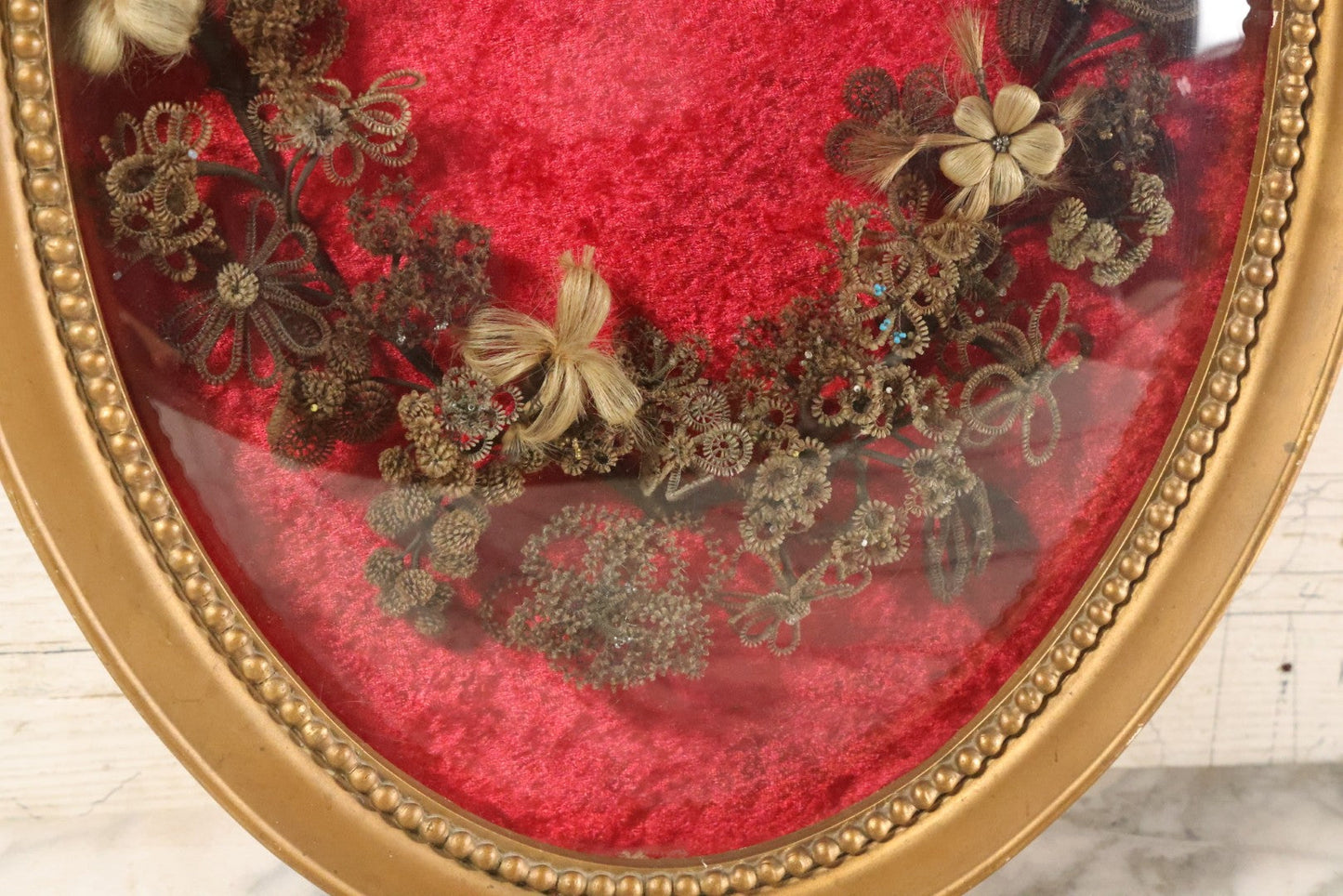 Lot 008 - Antique Victorian Human Hair Work Wreath In Oval Shadow Box With Bubble Glass, Refurbished Faux Red Velvet Back And Surround, 16" x 22"
