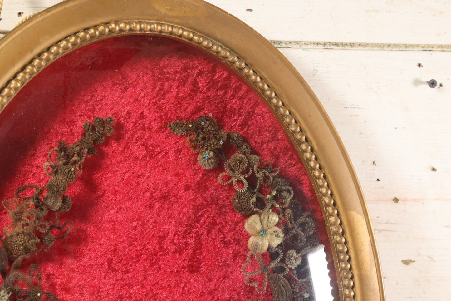 Lot 008 - Antique Victorian Human Hair Work Wreath In Oval Shadow Box With Bubble Glass, Refurbished Faux Red Velvet Back And Surround, 16" x 22"