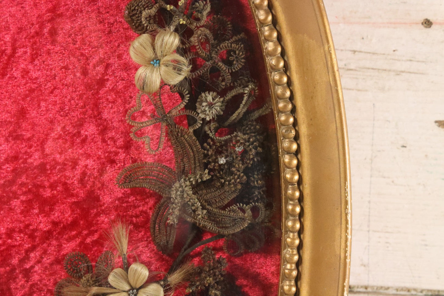 Lot 008 - Antique Victorian Human Hair Work Wreath In Oval Shadow Box With Bubble Glass, Refurbished Faux Red Velvet Back And Surround, 16" x 22"