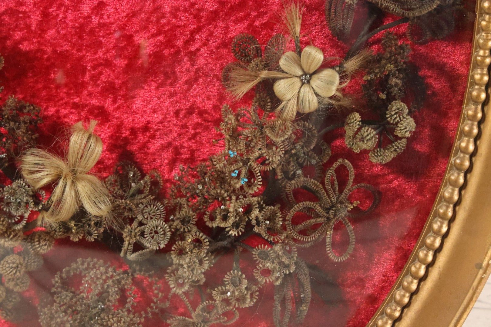 Lot 008 - Antique Victorian Human Hair Work Wreath In Oval Shadow Box With Bubble Glass, Refurbished Faux Red Velvet Back And Surround, 16" x 22"