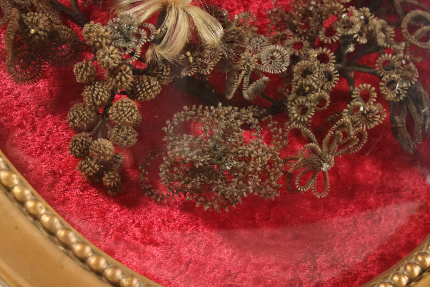 Lot 008 - Antique Victorian Human Hair Work Wreath In Oval Shadow Box With Bubble Glass, Refurbished Faux Red Velvet Back And Surround, 16" x 22"