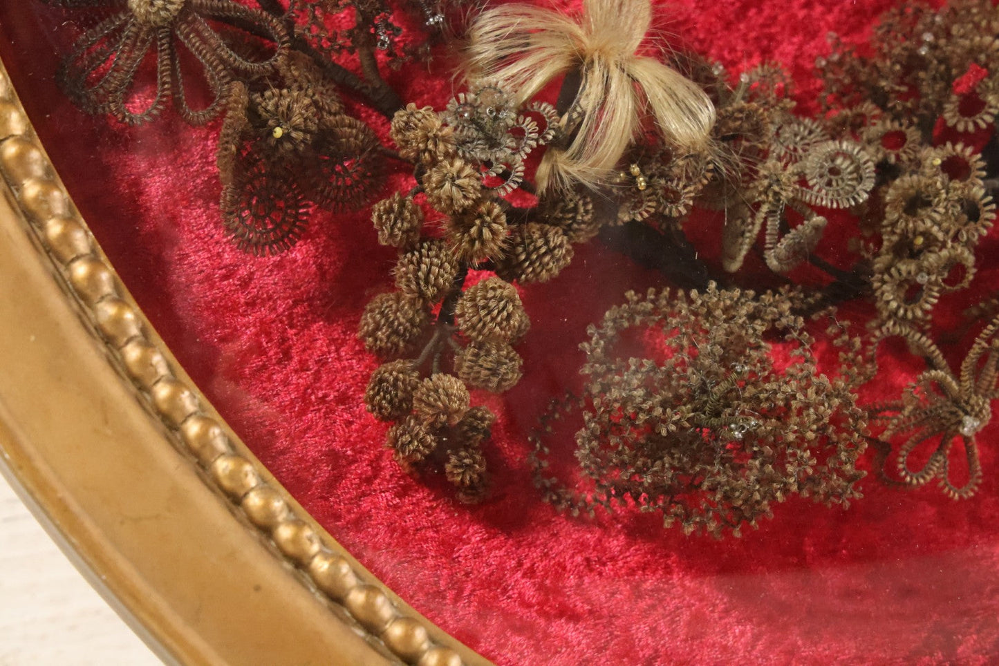 Lot 008 - Antique Victorian Human Hair Work Wreath In Oval Shadow Box With Bubble Glass, Refurbished Faux Red Velvet Back And Surround, 16" x 22"