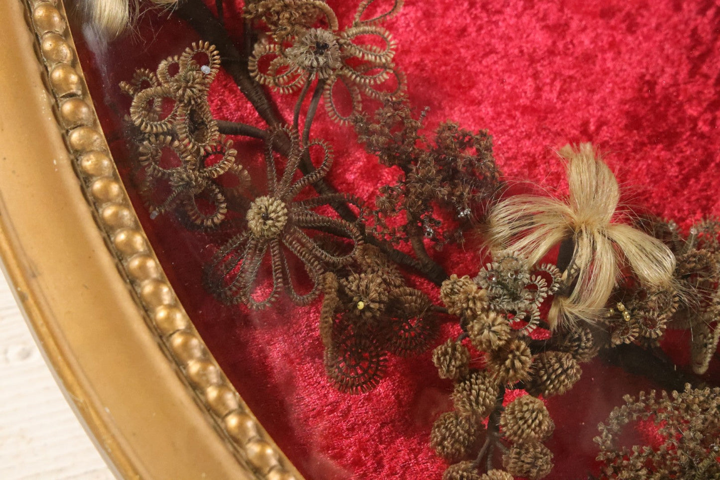 Lot 008 - Antique Victorian Human Hair Work Wreath In Oval Shadow Box With Bubble Glass, Refurbished Faux Red Velvet Back And Surround, 16" x 22"