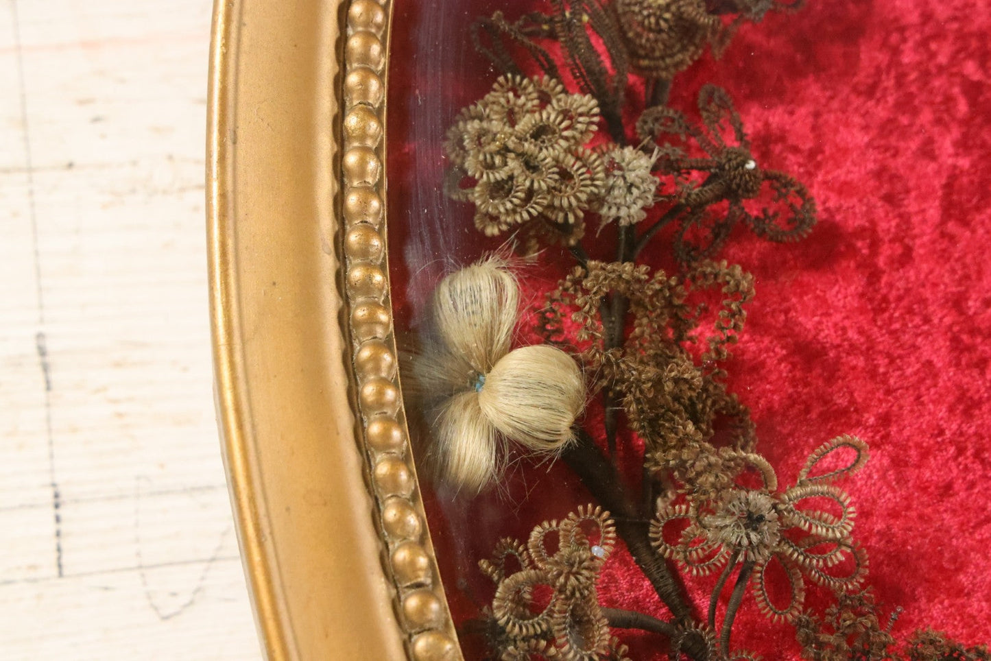 Lot 008 - Antique Victorian Human Hair Work Wreath In Oval Shadow Box With Bubble Glass, Refurbished Faux Red Velvet Back And Surround, 16" x 22"