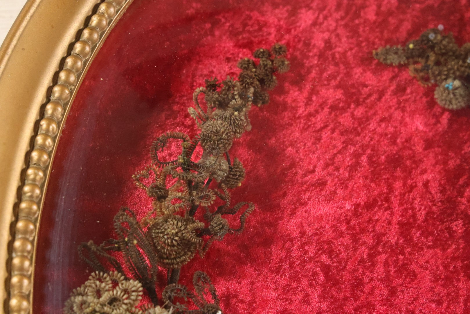 Lot 008 - Antique Victorian Human Hair Work Wreath In Oval Shadow Box With Bubble Glass, Refurbished Faux Red Velvet Back And Surround, 16" x 22"