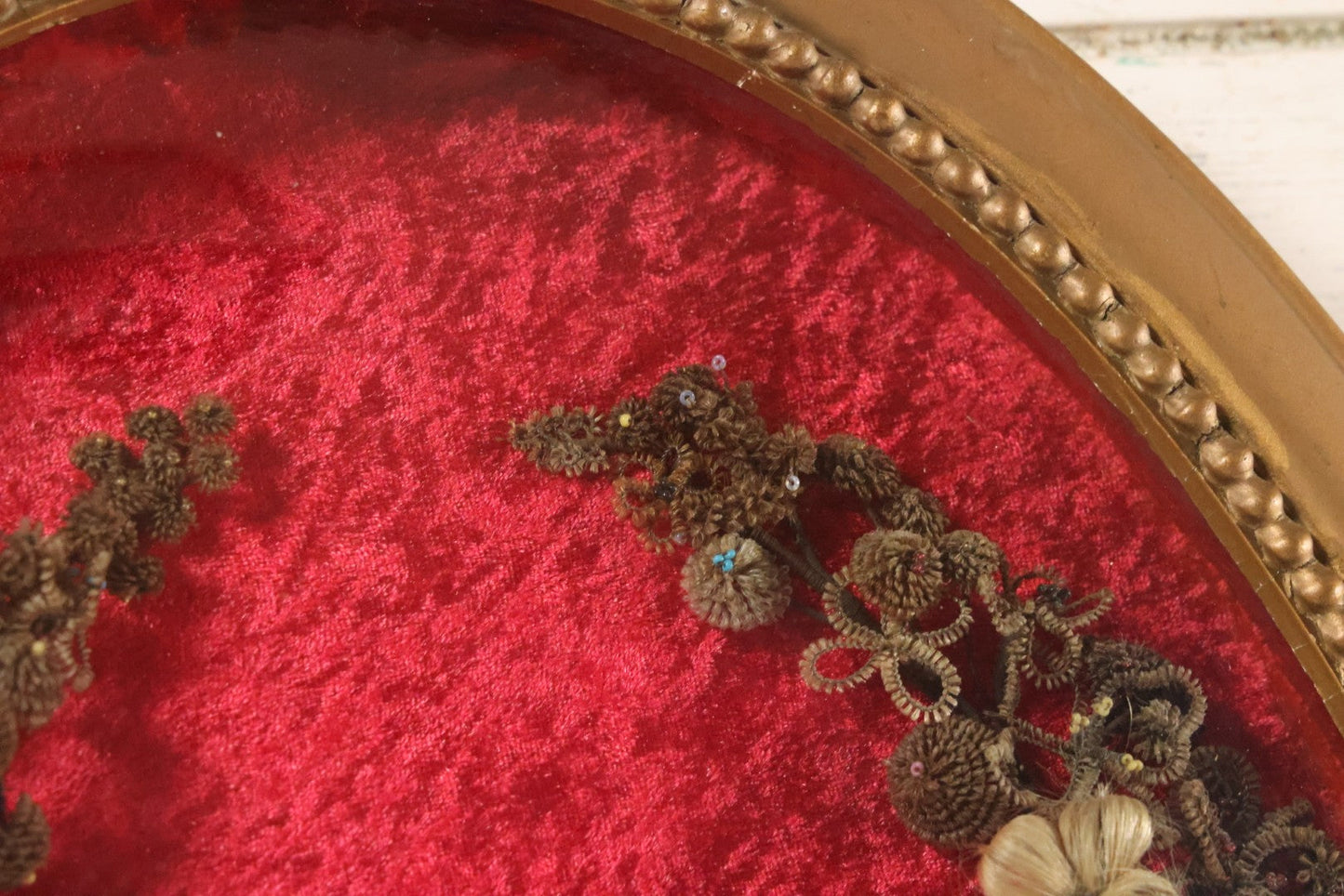 Lot 008 - Antique Victorian Human Hair Work Wreath In Oval Shadow Box With Bubble Glass, Refurbished Faux Red Velvet Back And Surround, 16" x 22"
