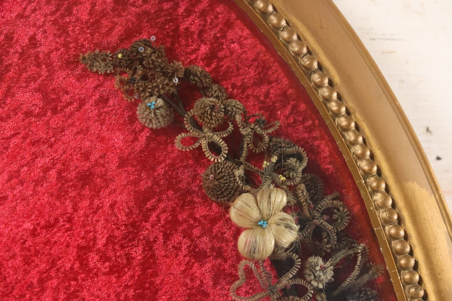 Lot 008 - Antique Victorian Human Hair Work Wreath In Oval Shadow Box With Bubble Glass, Refurbished Faux Red Velvet Back And Surround, 16" x 22"