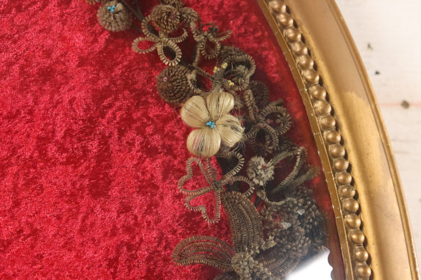 Lot 008 - Antique Victorian Human Hair Work Wreath In Oval Shadow Box With Bubble Glass, Refurbished Faux Red Velvet Back And Surround, 16" x 22"