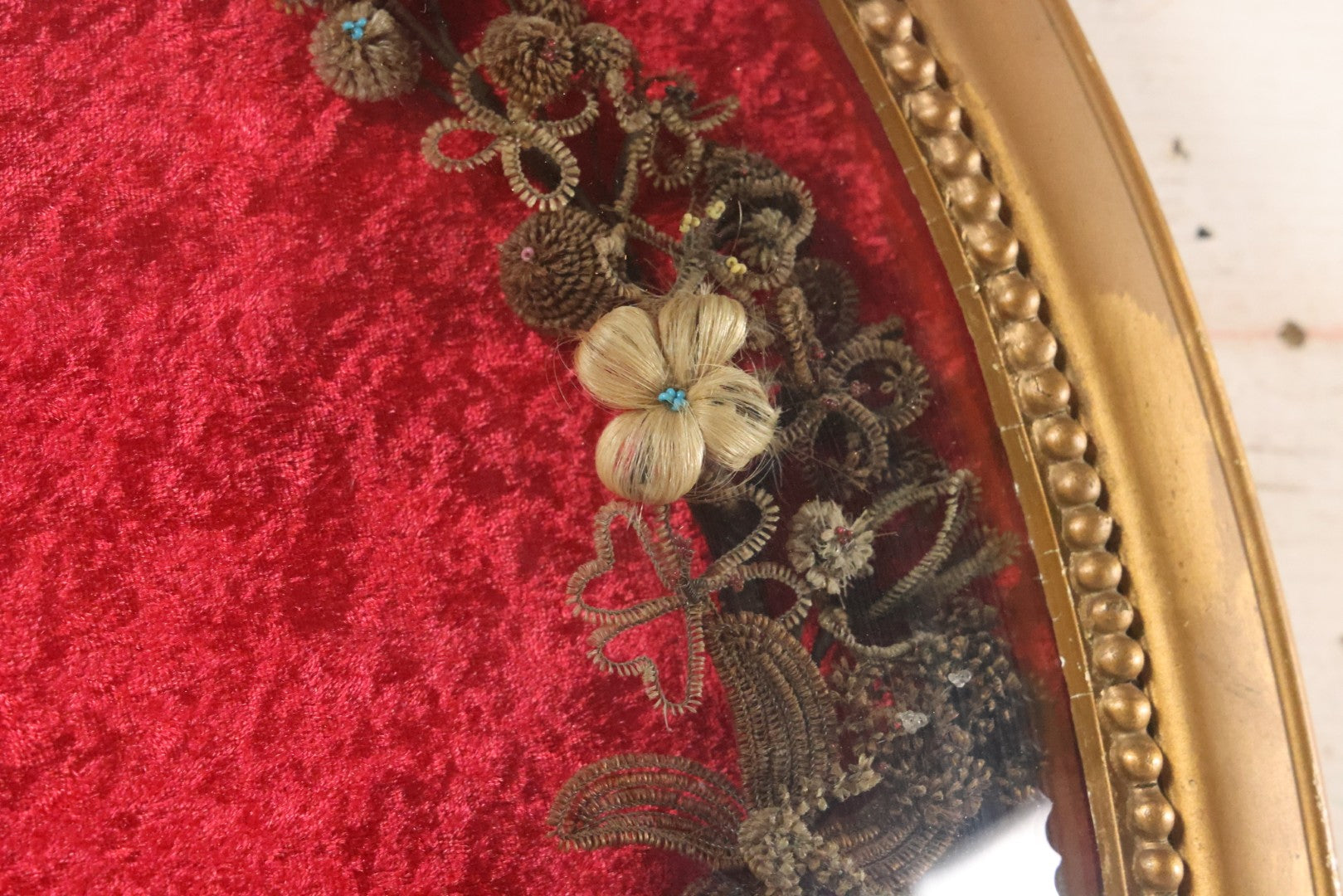 Lot 008 - Antique Victorian Human Hair Work Wreath In Oval Shadow Box With Bubble Glass, Refurbished Faux Red Velvet Back And Surround, 16" x 22"