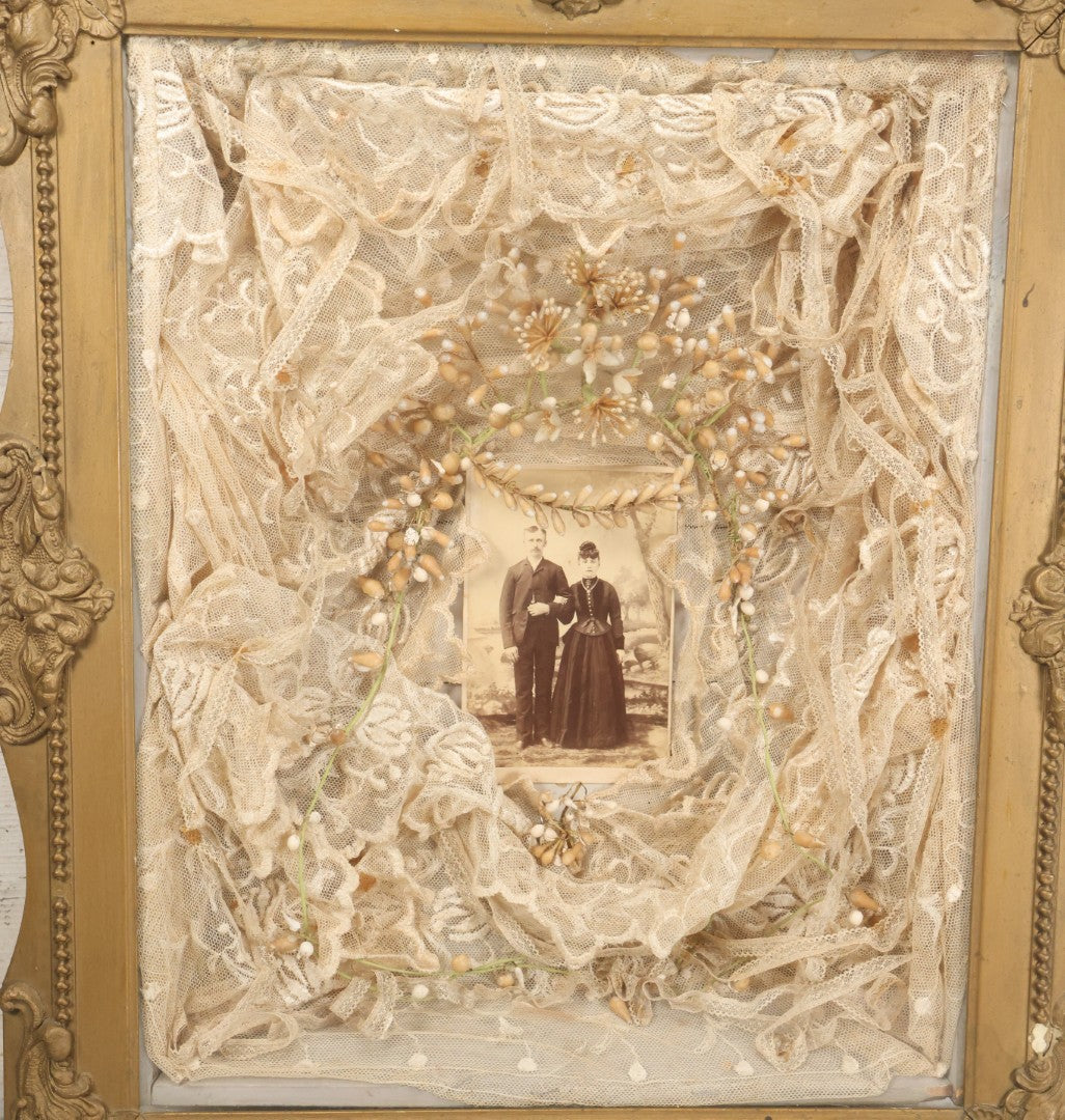 Lot 009 - Antique Victorian Wedding Commemoration Shadow Box With Lace Wedding Veil, Faux Floral Adornments, Cabinet Card Photograph Of Couple At Center, In Gesso Frame, 20-1/2" x 24-1/2" x 3-3/4"