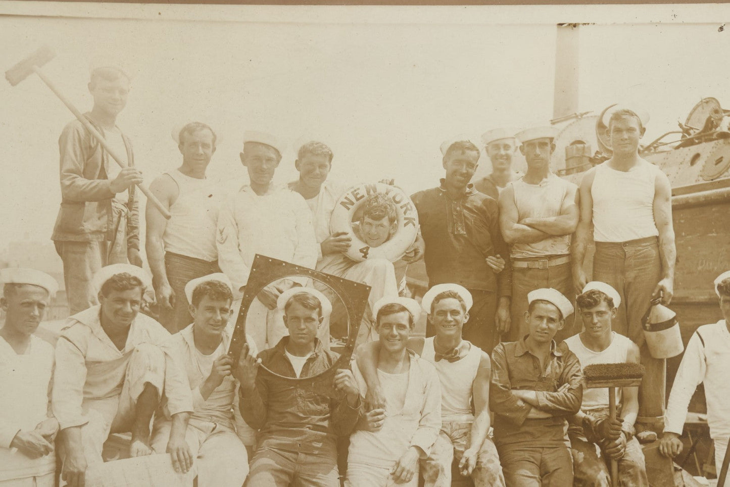 Lot 019 - Antique Boarded Photograph In Frame Of "The Steamboat Gang Of The New York," 1915, Occupational Photos Of Navy Sailors On Dock, With Tools Of The Trade, Other Workers In Background, U.S.S. New York (BB-34), 15-1/2" x 13-1/2"