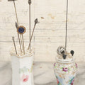 Lot 040 - Grouping Of Twelve Antique Hat Pins And Two Porcelain Hat Pin Holders, Including Some With Sterling, Blue Gem, Art Nouveau, And More