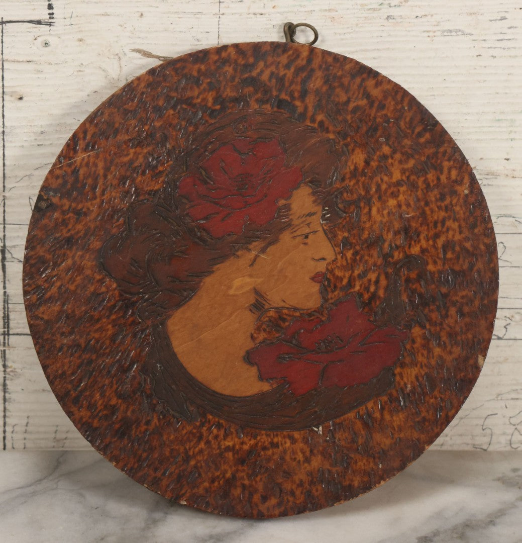 Lot 047 - Antique Flemish Art Pyrography Wood Burned Wall Hanger Disc With "Gibson Girl" Style Woman With Red Lipstick, Flowers, 7-3/4" Diameter