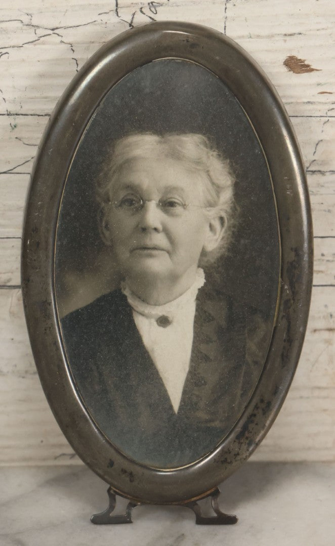 Lot 074 - Antique Oval Shaped Sterling Silver Frame With A Photograph Of An Elderly Woman, Note Missing Kickstand On Back, Marked Sterling, 3" x 5-3/8"