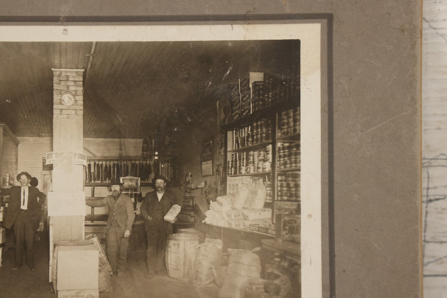 Lot 080 - Antique Boarded Occupational Photograph Of The Interior Of A General Store With Four Men In Frame, Many Products, Advertisements, Note Corner Losses