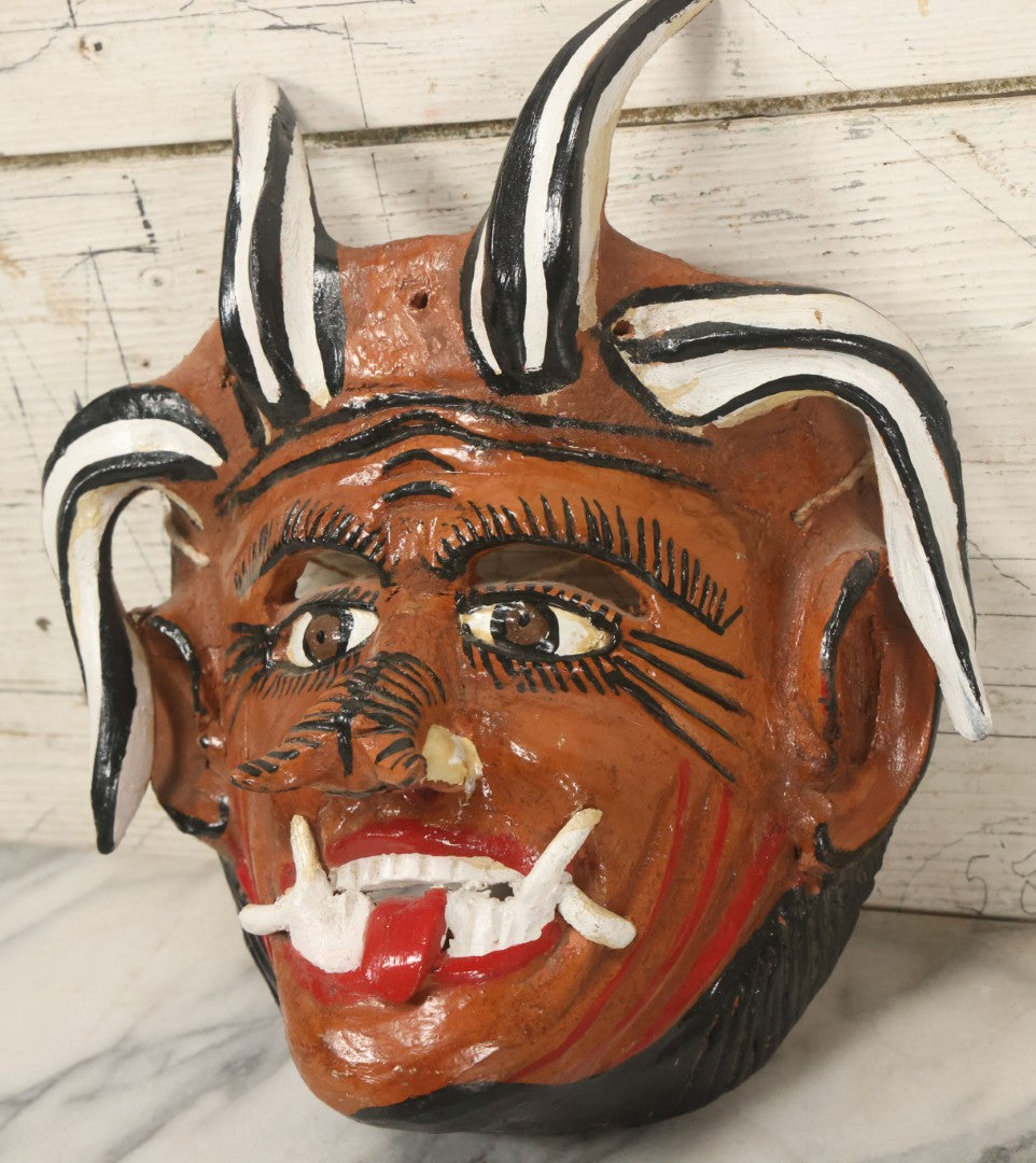 Lot 013 - Vintage Clay Devil Demon Mask With Curly Black And White Horns, Fangs, And Forked Nose, Hand Sculpted, Hand Painted, With Rope Hanger