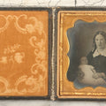 Lot 027 - Antique 1/6th Plate Ambrotype Photograph Of Young Mother Holding Newborn Baby, Wearing Tinted Jewelry, In Full Leatherette Union Case, Note Spine Repaired With Tape