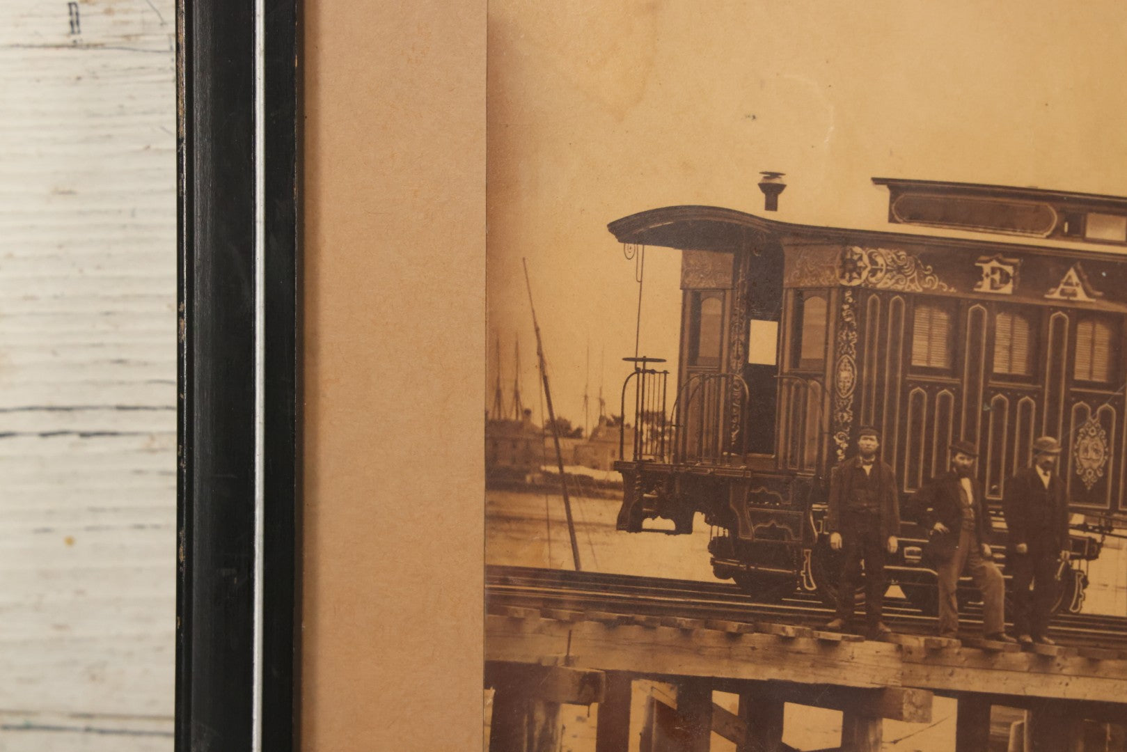 Lot 037 - Antique Boarded Occupational Photograph Of Newly Built Eastern Railroad Passenger Train Car, With Workers Pictured On Train Track, In Front Of Harbor, In Frame, Note Water Stains, 15-5/8" x 11-1/4"
