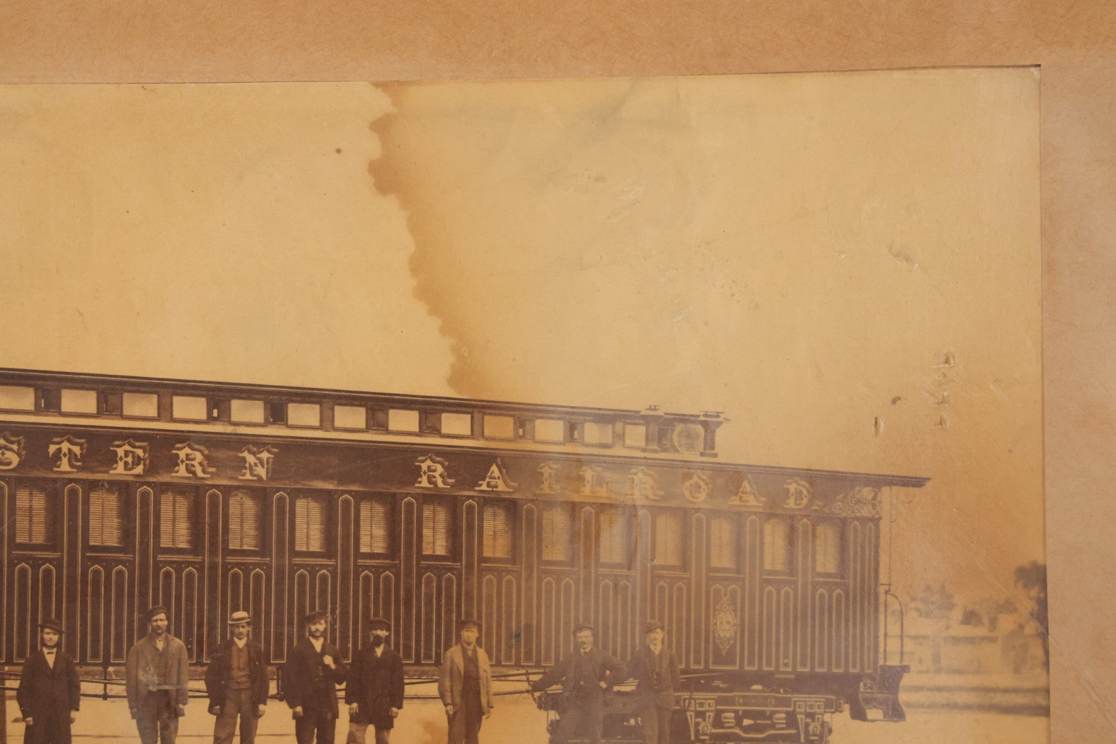 Lot 037 - Antique Boarded Occupational Photograph Of Newly Built Eastern Railroad Passenger Train Car, With Workers Pictured On Train Track, In Front Of Harbor, In Frame, Note Water Stains, 15-5/8" x 11-1/4"