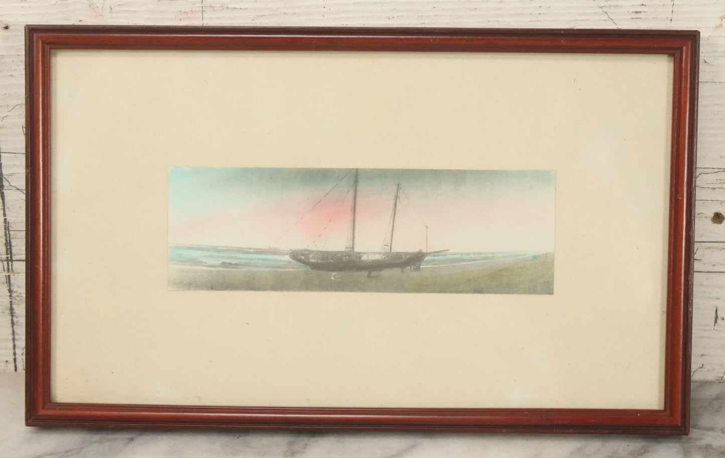 Lot 040 - Vintage Hand Tinted Photograph Of Sailboat Washed Up On Shore At Sunset, In Frame, 11" x 6-3/4"