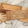 Lot 079 - Antique Slide Top Wooden Mailing Box From Edward E Dammers, Optician, Worcester, Massachusetts, Containing Two Pairs Of Antique Eyeglasses And Advertising Ephemera, Addressed To Mary Fickett, As Found, Note Cracks And Wear