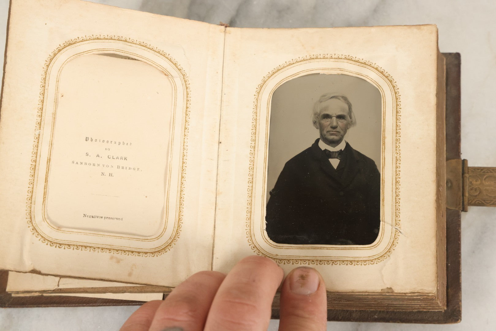 Lot 123 - Antique Cabinet Card And Tintype Family Photo Album, 3 C.D.V. Photos, 10 Tintypes, 2 Illustrated Album Filler Cards, Including Tintype Of Scowling Old Man And Illustrated Card Of Civil War Commander Foot, Cover With Harlequin And Fairy Motif