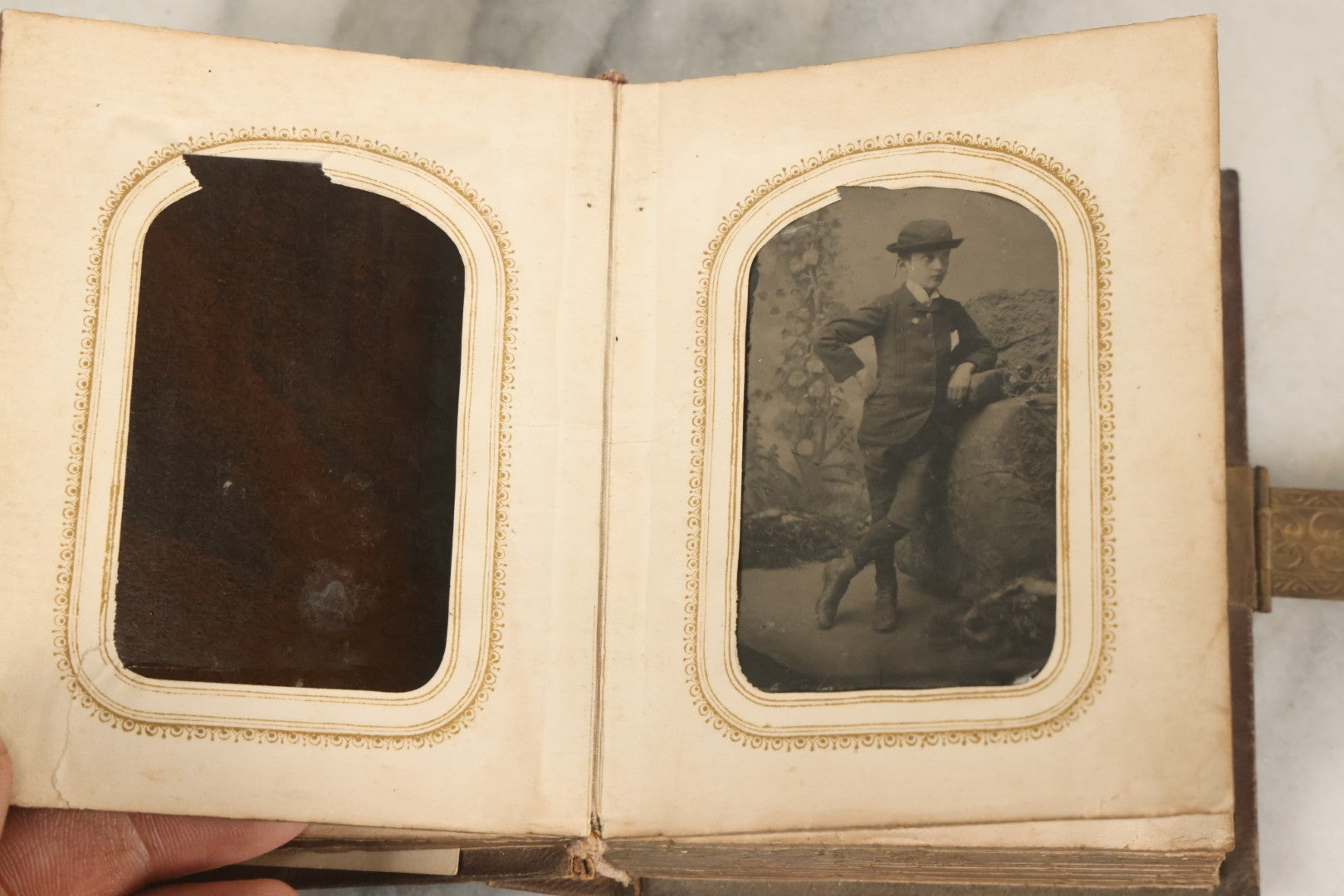 Lot 123 - Antique Cabinet Card And Tintype Family Photo Album, 3 C.D.V. Photos, 10 Tintypes, 2 Illustrated Album Filler Cards, Including Tintype Of Scowling Old Man And Illustrated Card Of Civil War Commander Foot, Cover With Harlequin And Fairy Motif