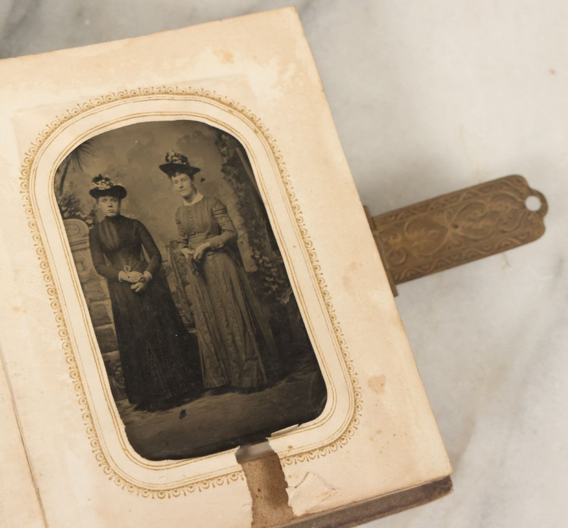 Lot 123 - Antique Cabinet Card And Tintype Family Photo Album, 3 C.D.V. Photos, 10 Tintypes, 2 Illustrated Album Filler Cards, Including Tintype Of Scowling Old Man And Illustrated Card Of Civil War Commander Foot, Cover With Harlequin And Fairy Motif