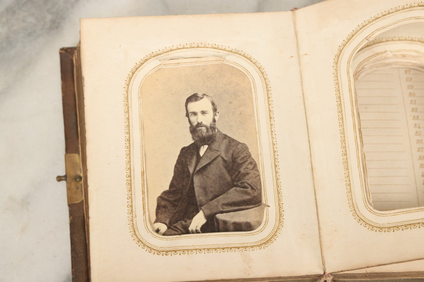 Lot 123 - Antique Cabinet Card And Tintype Family Photo Album, 3 C.D.V. Photos, 10 Tintypes, 2 Illustrated Album Filler Cards, Including Tintype Of Scowling Old Man And Illustrated Card Of Civil War Commander Foot, Cover With Harlequin And Fairy Motif