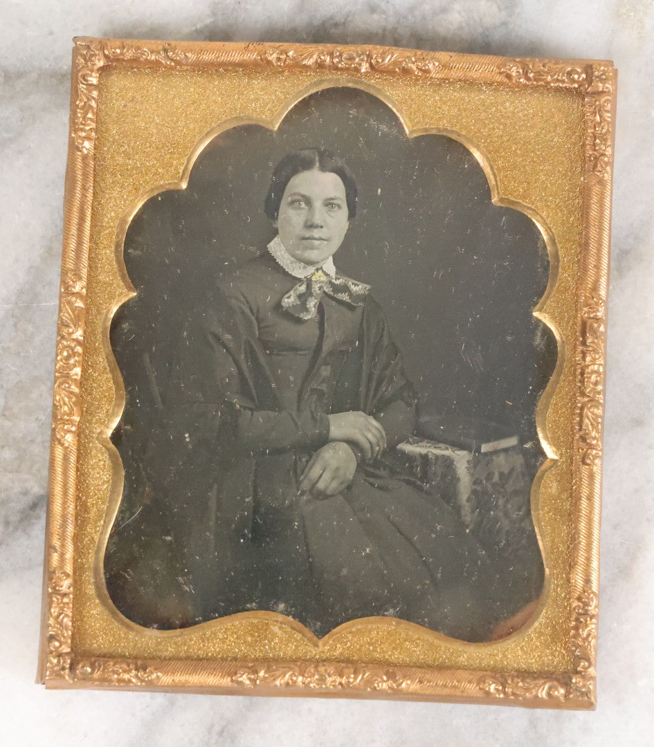 Lot 055 - Antique 1/6th Plate Daguerreotype Photograph Of Middle Aged Woman With Paisley Necktie Seated With A Book On Table
