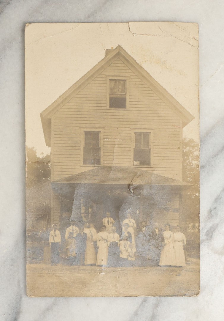 Lot 094 - Antique Occupational Real Photo Postcard R.P.P.C. Of The Proprietors And Workers Of A General Store Outside The Building, Sign Reads "Buck"