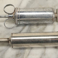 Lot 038 - Pair Of Antique Metal Syringes Including Empire By Becton, Dickinson, & Co., Rutherford, New Jersey