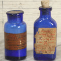 Lot 005 - Pair Of Antique Cobalt Blue Glass Pharmacy Bottles, Including Poison Bottle With Partial Paper Label, And Camphoric Acid Bottle