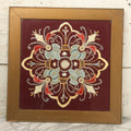 Lot 028 - Vintage Folk Art Needlepoint Embroidery Medallion With Blue, Red, And Yellow Thread On Maroon Field, In Frame