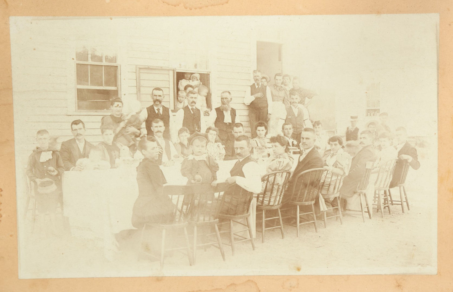 Lot 094 - Antique Framed Boarded Photograph Of A Large Family Gathering Meal Outside, Possibly Thanksgiving Or Like Occasion, With Many Men, Women, And Children In Photo, Overall Dimensions 11-1/2" x 9-3/8"