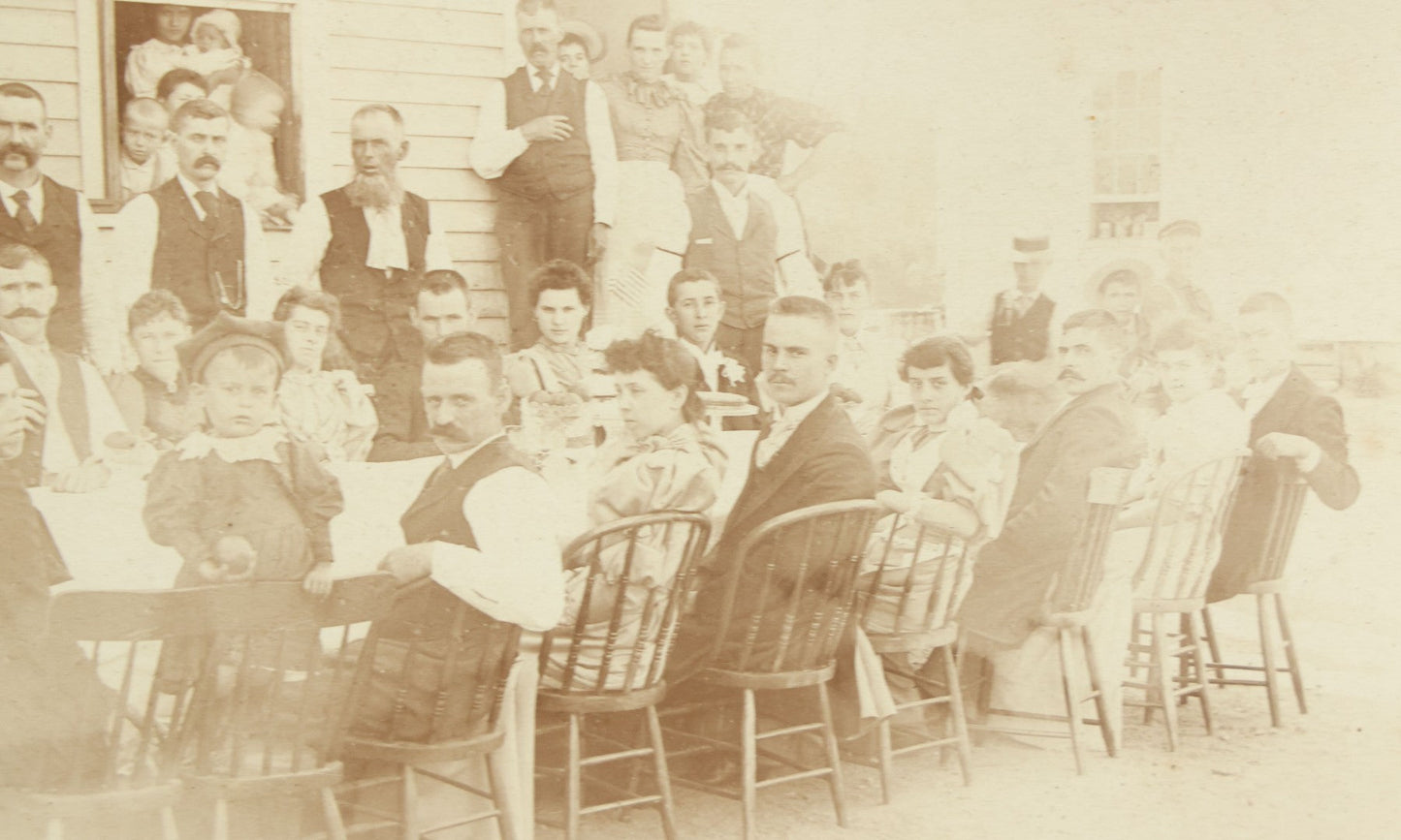 Lot 094 - Antique Framed Boarded Photograph Of A Large Family Gathering Meal Outside, Possibly Thanksgiving Or Like Occasion, With Many Men, Women, And Children In Photo, Overall Dimensions 11-1/2" x 9-3/8"