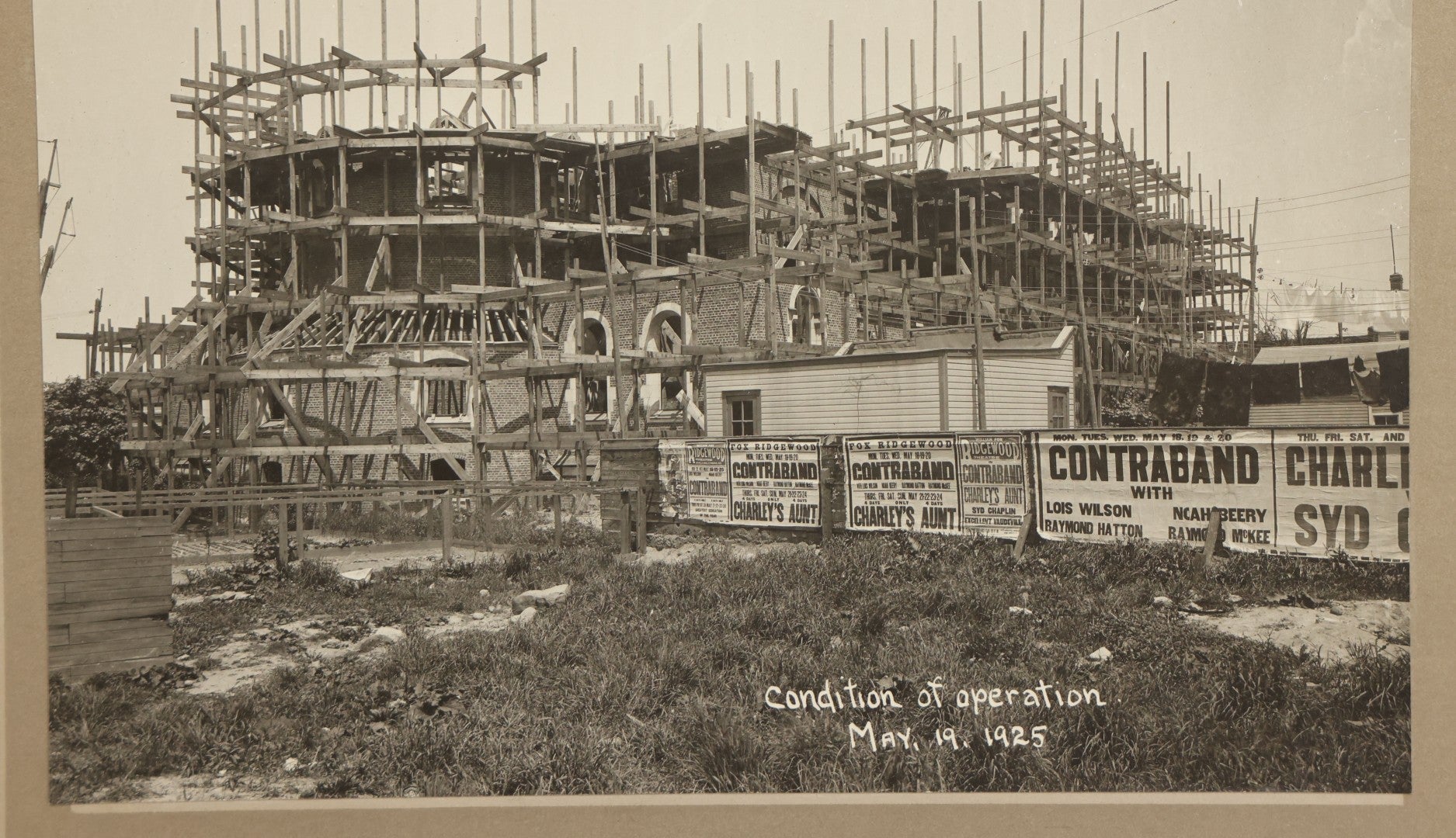 Lot 100 - Single Antique Boarded Photo Depicting A Building Under Construction, Possibly A Church In Queens, New York, With Posters Advertising The Fox Ridgewood Theater, Photo Marked "Condition Of Operations, May 19, 1925"