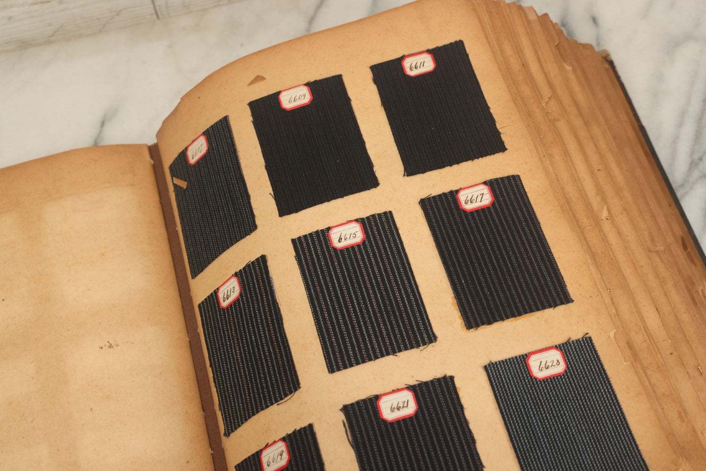 Lot 031 - Antique Sample Fabric Wool Swatch Book From Calumet Woolen Co., Styles No. And/Or Great River Woolen Co., Styles No. 6107-7785, Containing Dozens Of Fabric Samples, Missing Spine Covering, Circa 1894 