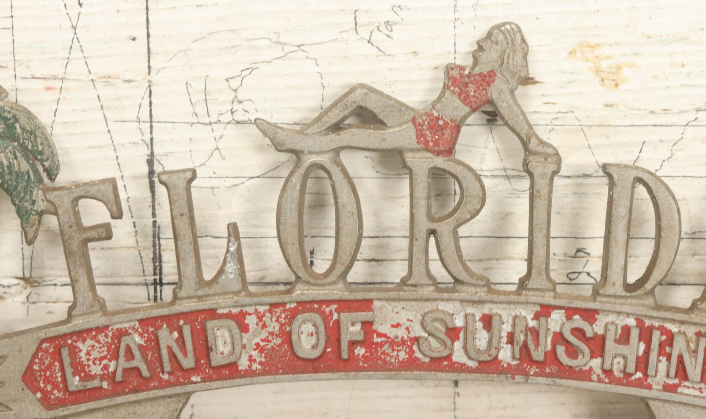 Lot 036 - Vintage Cast Aluminum Florida "Land Of Sunshine" License Plate Topper With Beach Babe In Bikini, Remnants Of Red And Green Paint