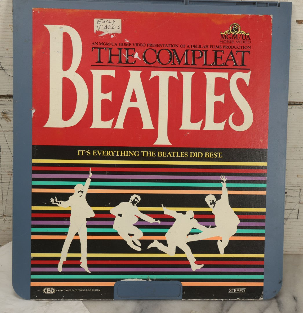 Lot 041 - Vintage "The Beatles" Band Collectibles Three Piece Grouping Including Plastic "We Love The Beatles" Shopping Bag, "The Compleat Beatles" Laserdisc, And Beatlefest 1984 Program