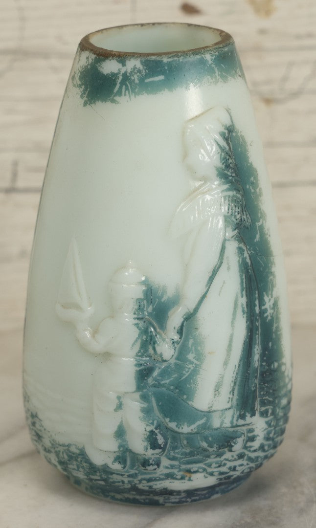 Lot 061 - Antique Molded Milk Glass Vase With Remnants Of Blue Paint Depicting A Young Child With His Toy Sailboat And Mother On The Beach, Note Various Chipping, 5-1/2" H