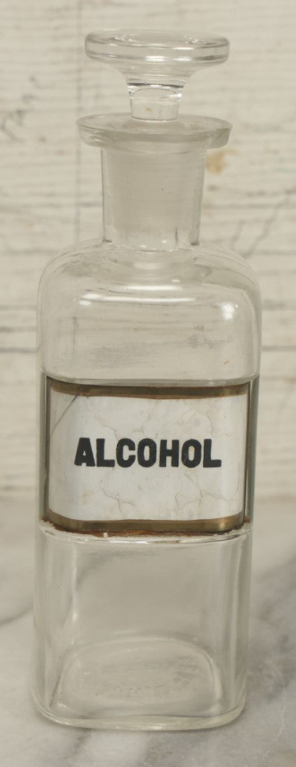 Lot 066 - Antique Whitall And Tatum Co. Glass Alcohol Apothecary Bottle Jar With Reverse Painted Glass Label, Note Chip To Lip Of Bottle, Crack In Label, 7" Height