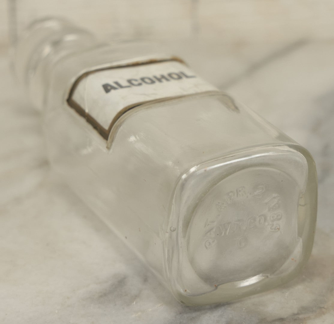 Lot 066 - Antique Whitall And Tatum Co. Glass Alcohol Apothecary Bottle Jar With Reverse Painted Glass Label, Note Chip To Lip Of Bottle, Crack In Label, 7" Height