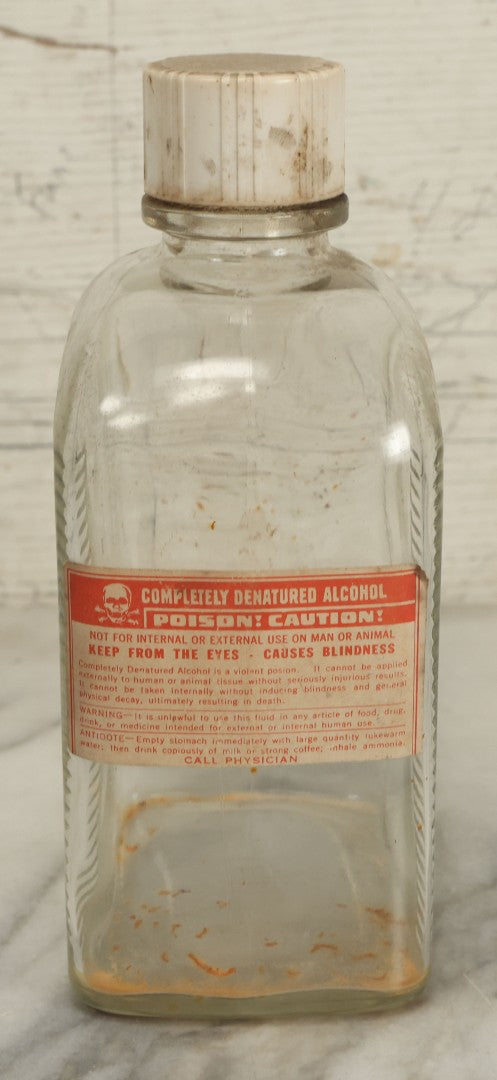 Lot 069 - Vintage Glass Pharmacy Jar Jug Bottle With Applied Paper Label, Completely Denatured Alcohol, Poison: Caution! With Skull And Crossbones, 7-5/8" Height