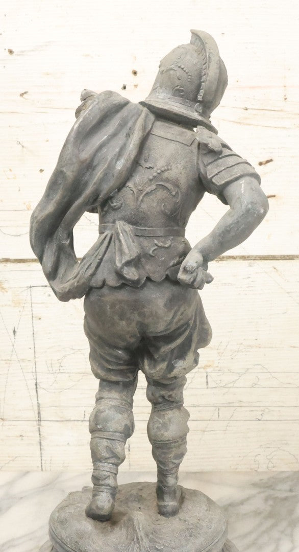 Lot 035 - Antique Spelter Metal Soldier Statue, Wearing Armor And Helmet, Note Missing Arm, Damaged / Warped Based, Overall Poor Condition, 16-1/2" Height