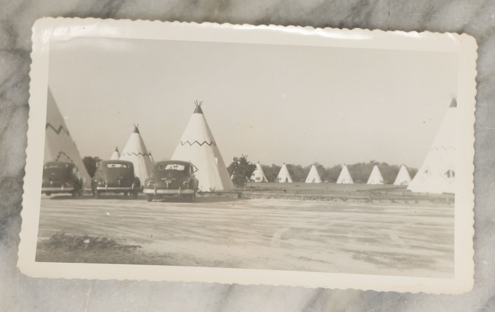 Lot 098 - Grouping Of Seven Vintage Snap Shot Photographs Including Child With Baby Deer Fawn, Man With Pelts, Teepee Campsite, Burned Boat, Etc.