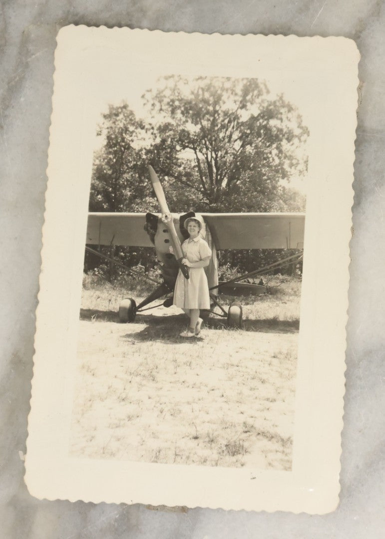 Lot 098 - Grouping Of Seven Vintage Snap Shot Photographs Including Child With Baby Deer Fawn, Man With Pelts, Teepee Campsite, Burned Boat, Etc.