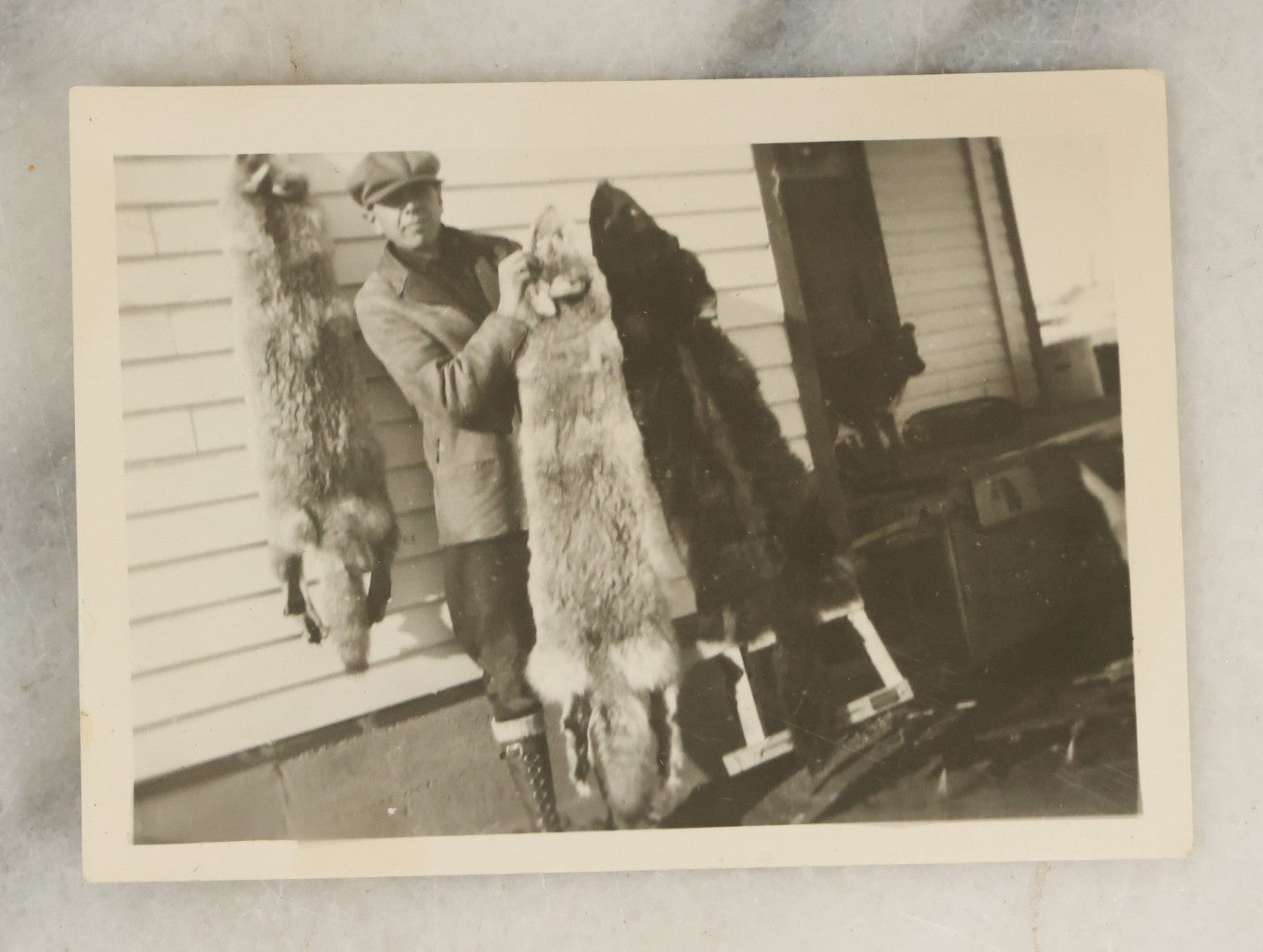 Lot 098 - Grouping Of Seven Vintage Snap Shot Photographs Including Child With Baby Deer Fawn, Man With Pelts, Teepee Campsite, Burned Boat, Etc.