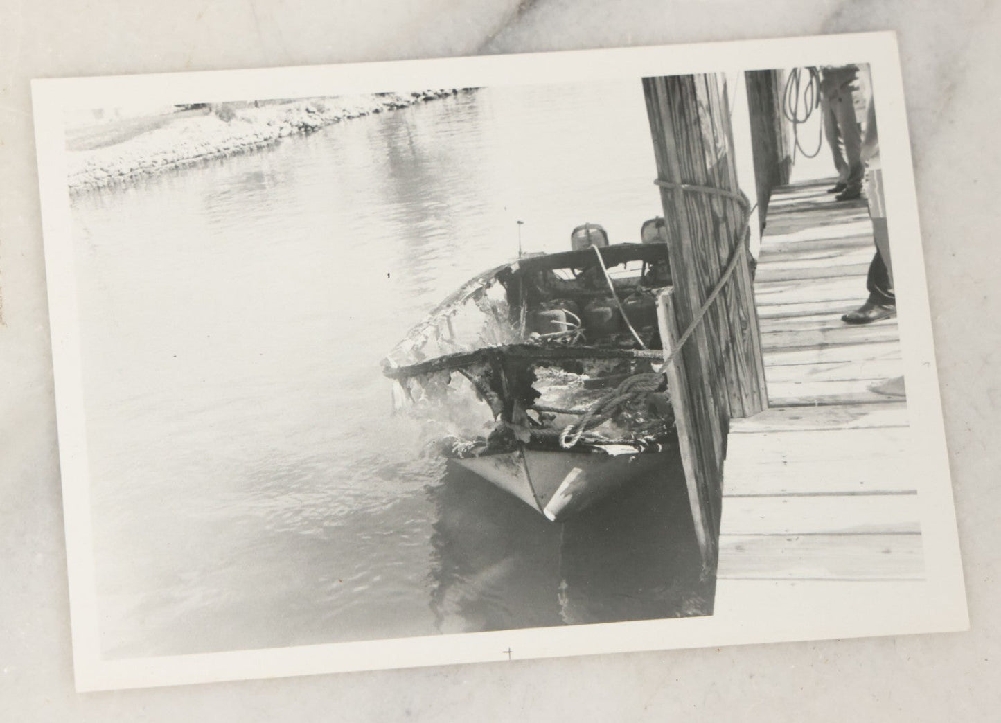Lot 098 - Grouping Of Seven Vintage Snap Shot Photographs Including Child With Baby Deer Fawn, Man With Pelts, Teepee Campsite, Burned Boat, Etc.